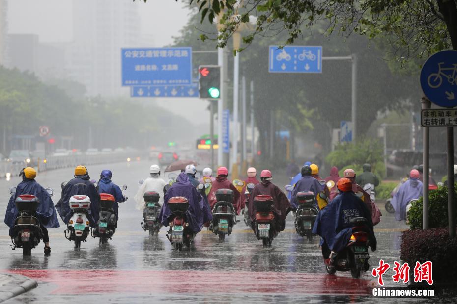 5月9日上午，强降雨袭击广西柳州市，市民身披雨具在路上骑行。 蒙鸣明 摄